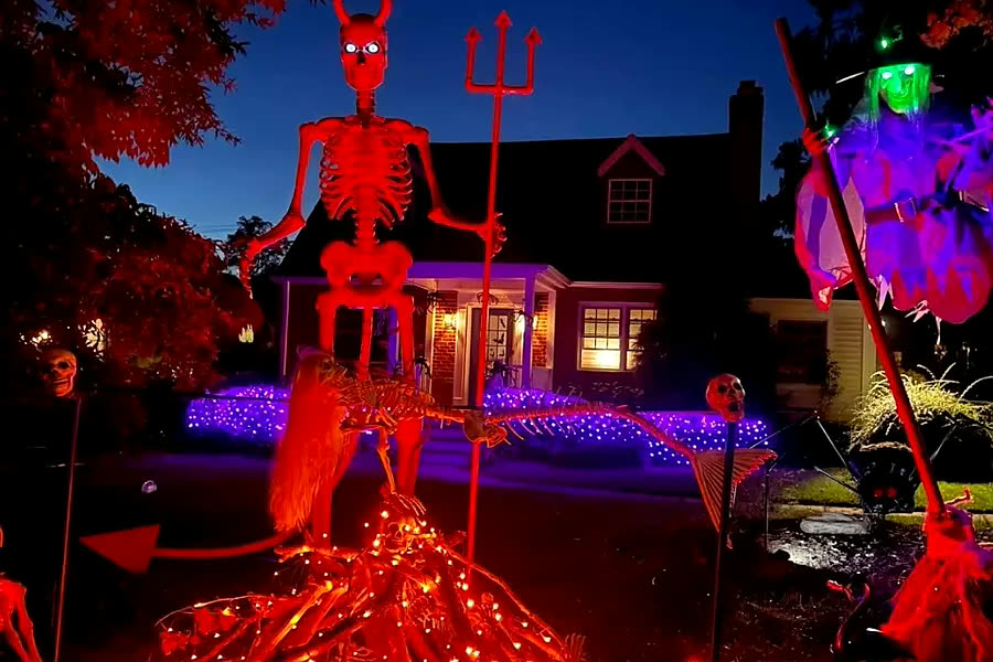 Halloween display with a giant skeleton and a witch